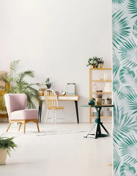 Home office corner with a green leaf wallpaper accent panel and light wood desk