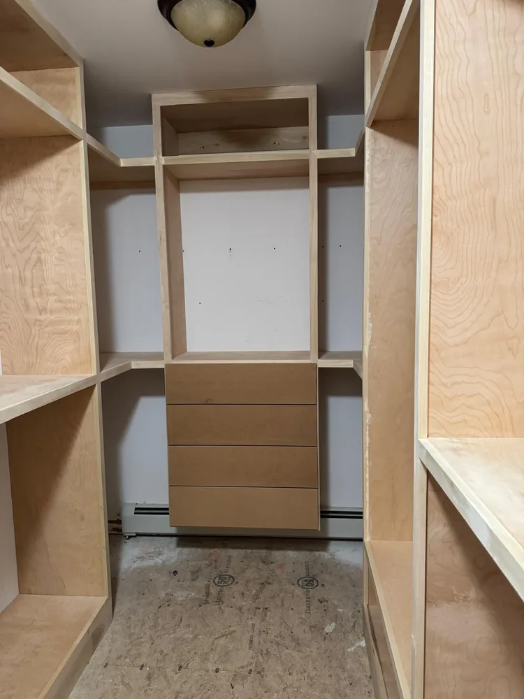 Wide view of a custom closet with shelving across three walls