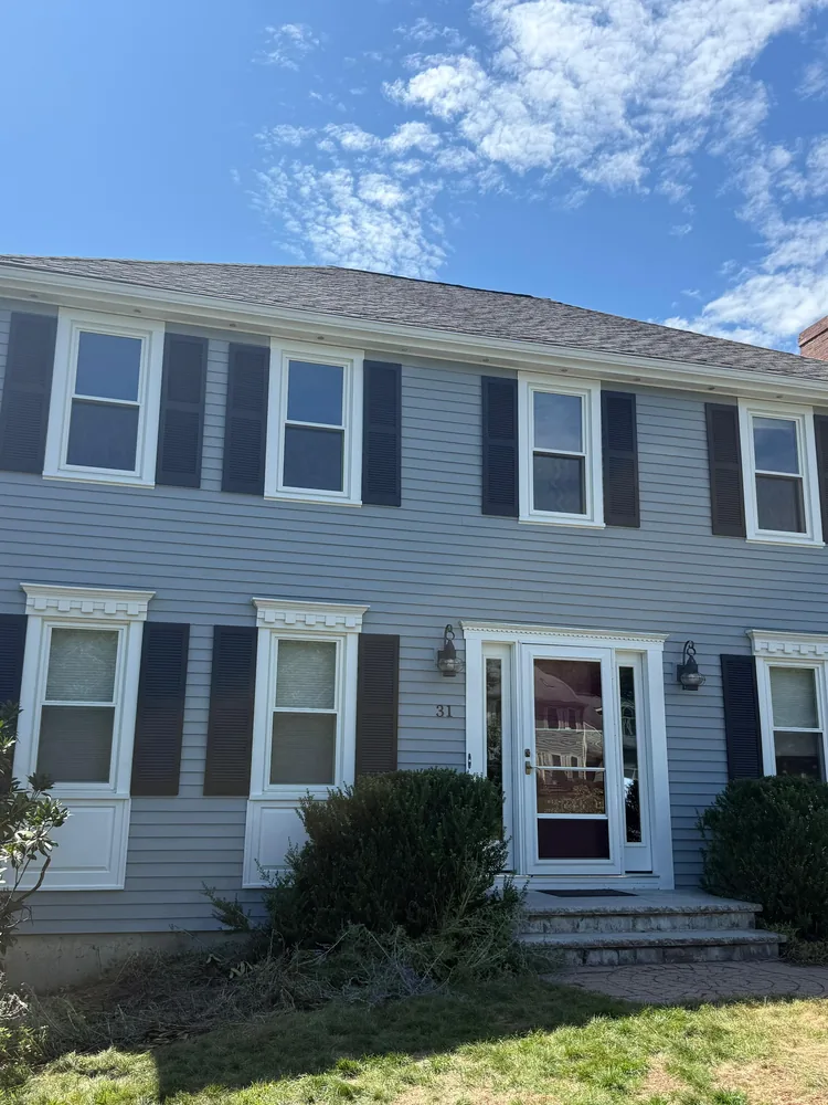Colonial with crisp white trim, dark shutters and a white front door