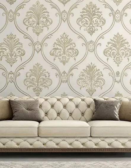 Living room wall covered in gold damask wallpaper above a tufted cream sofa