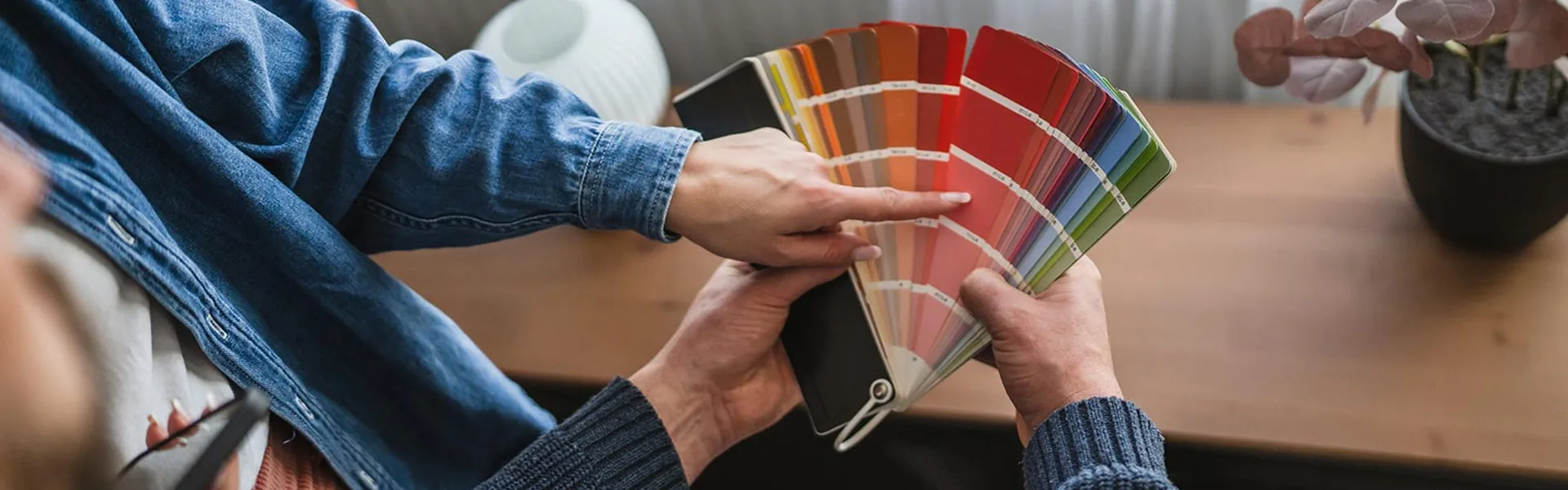 Homeowner and painter comparing paint colour fan decks at a table in Framingham Massachusetts
