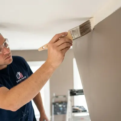 Painter cutting a crisp ceiling line with an angled brush