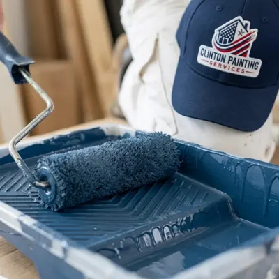 Roller loaded with denim blue paint in a tray