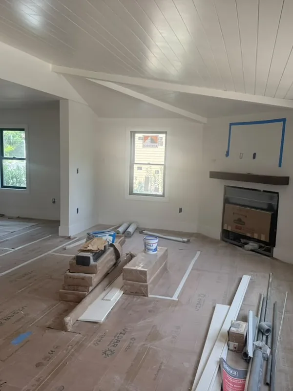 Living room mid renovation, with a fireplace and the floor protected