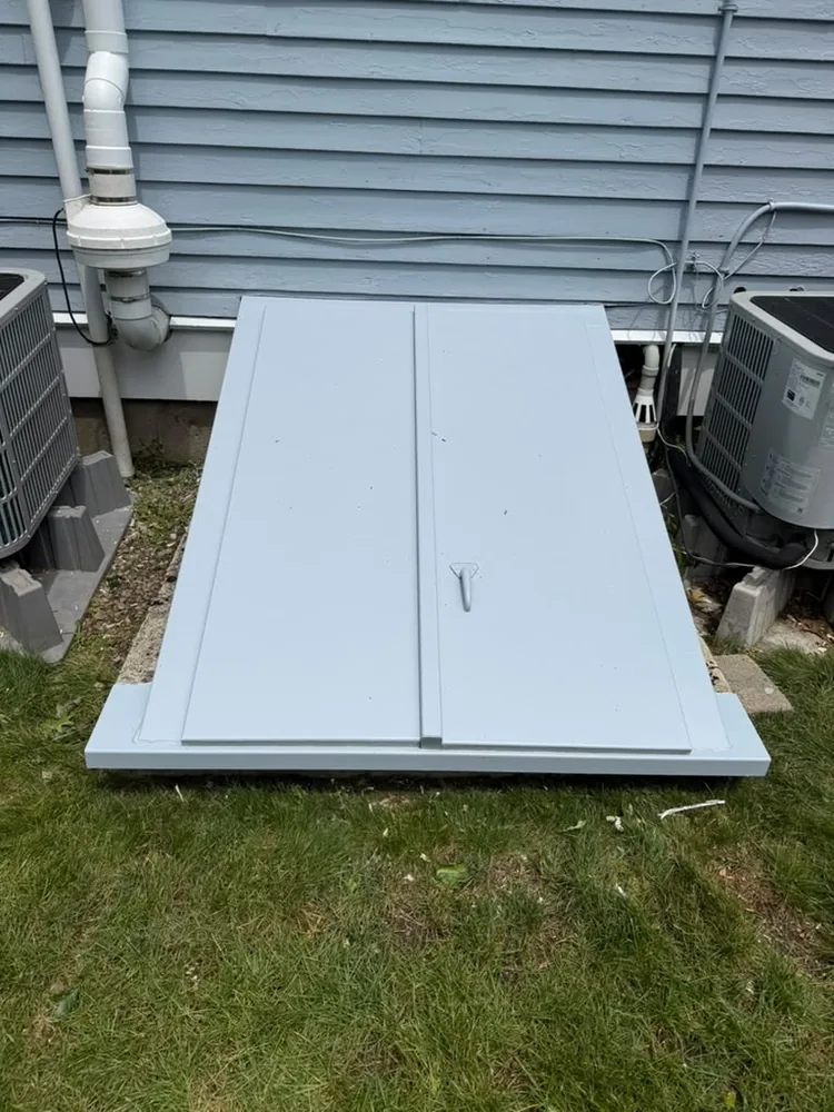 Freshly painted bulkhead door beside the house foundation