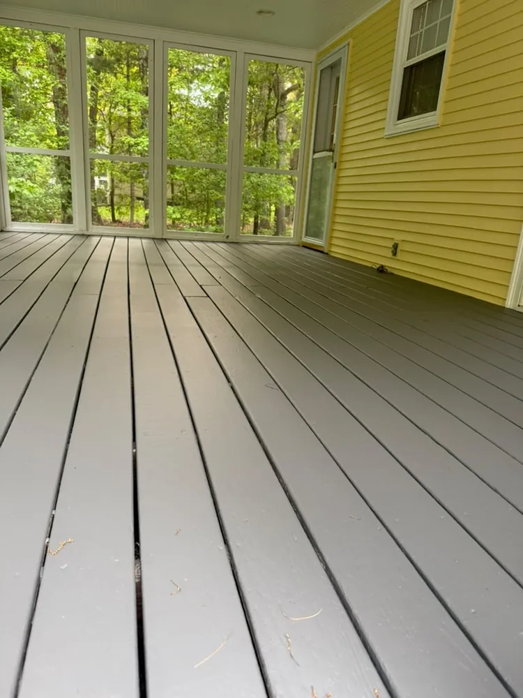 Porch floor freshly painted gray on a yellow house