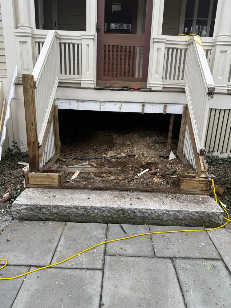 Front porch stairs stripped down to the frame at the start of a rebuild