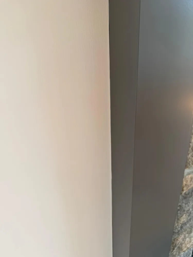 Corner where a cream wall meets a gray wall in a clean cut line