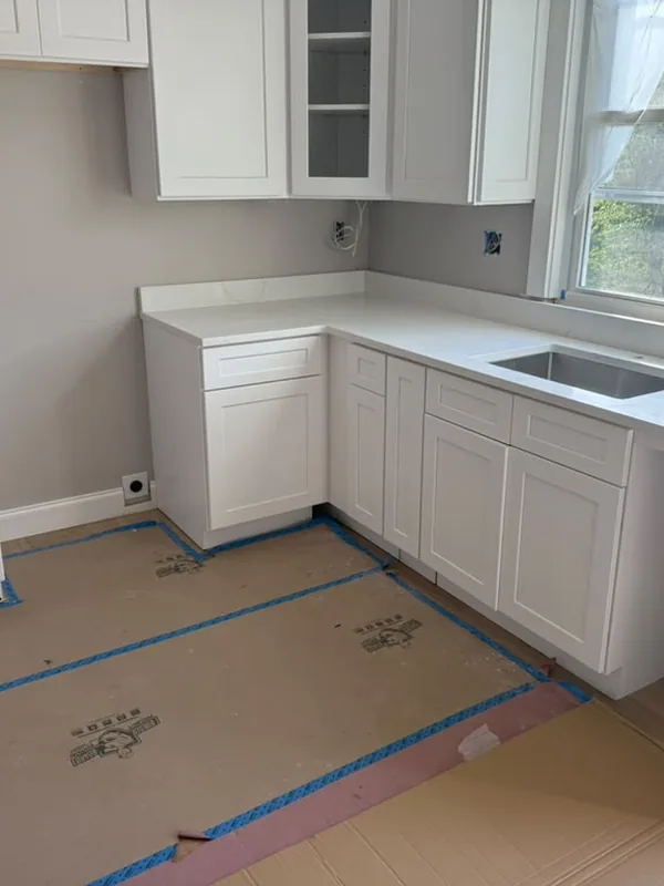 White kitchen cabinets set in place before the counters go in
