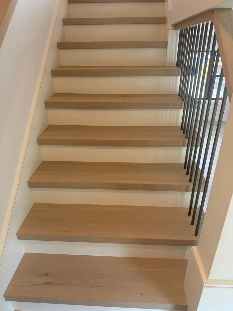Staircase with white oak treads, white risers and slim black balusters